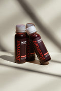 Three bottles of beetroot endurance shots with white caps on a beige background